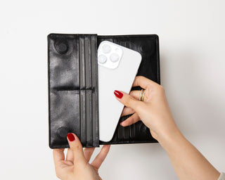 Hands holding an open Venito leather wallet with cards